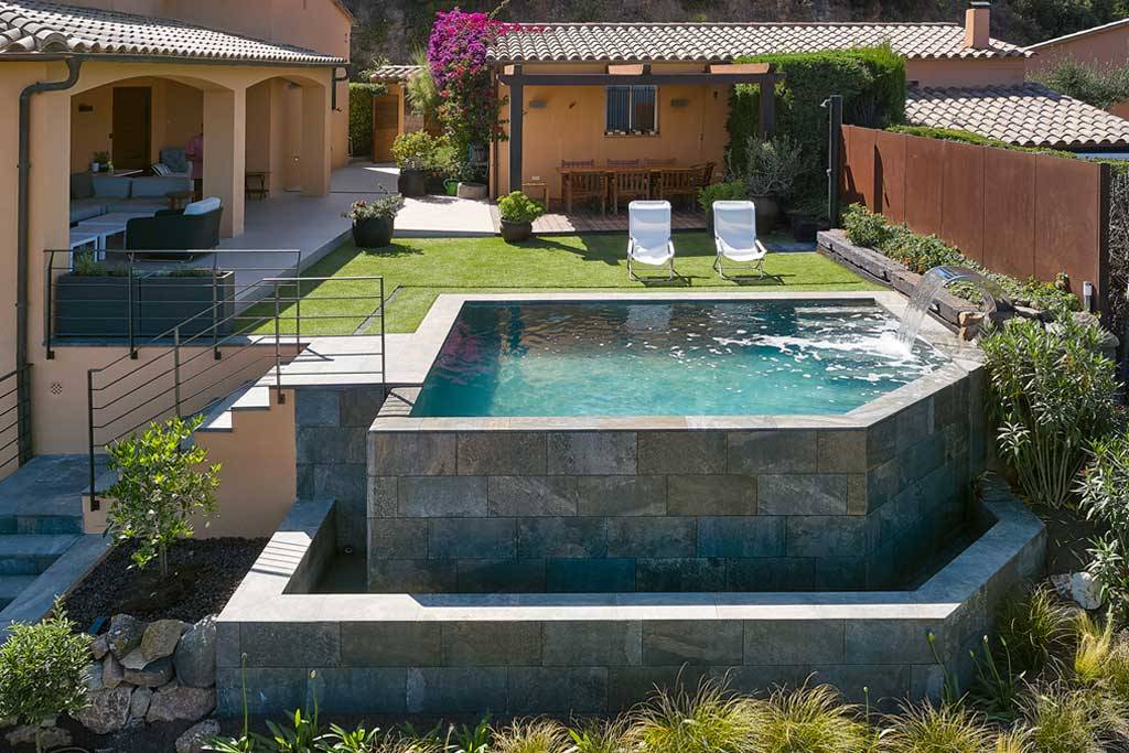 Réalisation d'une piscine sur pilotis à débordement en béton armé.