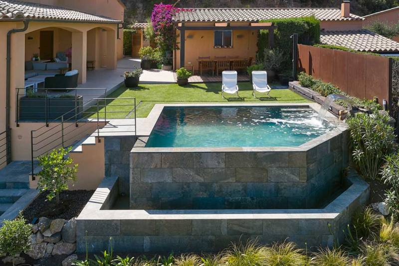 Réalisation d'une piscine sur pilotis à débordement en béton armé.