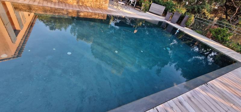 Conception d'une piscine miroir de forme atypique avec terrasse bois