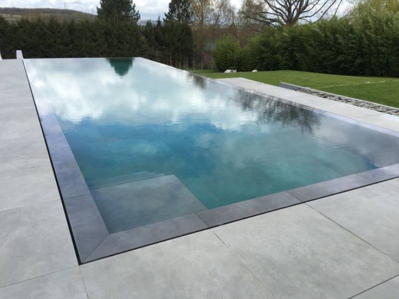 Structure Batibloc pour piscine miroir intégrée à une terrasse de style contemporain. Performance de l'isolation et pureté des lignes architecturales.