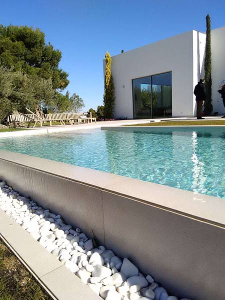 Conception d'un bassin à débordement pour une villa contemporaine à Fréjus. L'alliance de la structure isolante Batibloc et d'un design épuré.