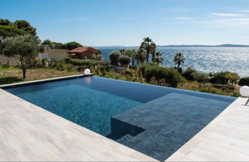 Perspective infinie et ligne d'eau parfaite pour cette piscine béton armé à débordement, une réalisation qui sublime l'horizon de votre villa.