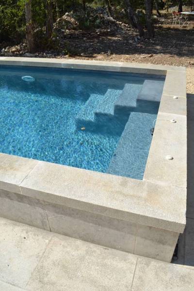 L'élégance du bassin suspendu : l'alliance d'une structure en piscine béton armé sur pilotis et d'une finition haut de gamme.